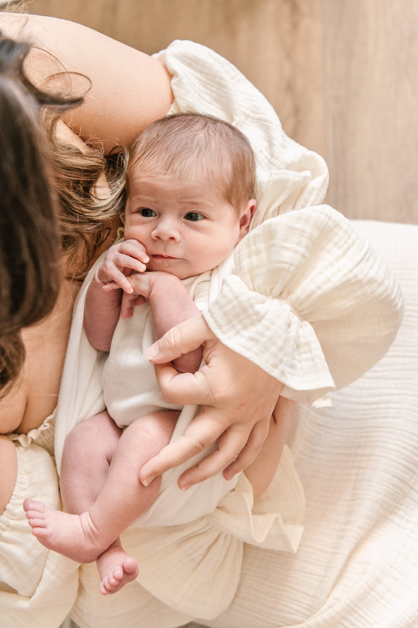  New Jersey photographer Nicole Hawkins Photography captures a newborn baby looking up at her mother. baby girl and momma sweet new baby #NicoleHawkinsPhotography #NicoleHawkinsNewborns #Babygirl #inhomenewbornsNJ #homenewbonportraits #inhomenewborns