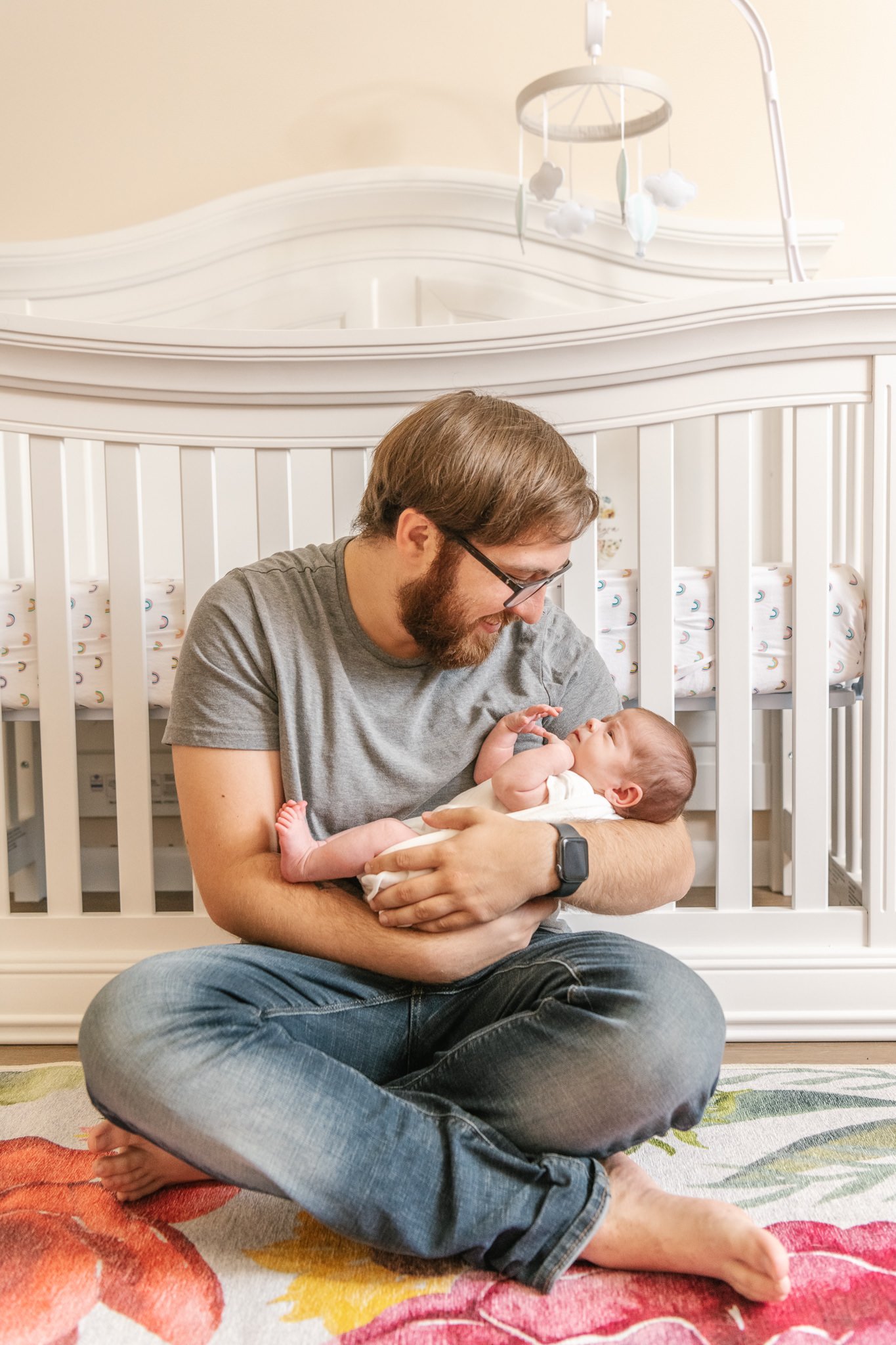  A father holds his newborn baby girl in his arms and smiles sweetly at her by Nicole Hawkins Photography. father holding baby girl #NicoleHawkinsPhotography #NicoleHawkinsNewborns #Babygirl #inhomenewbornsNJ #homenewbonportraits #inhomenewborns #NJn