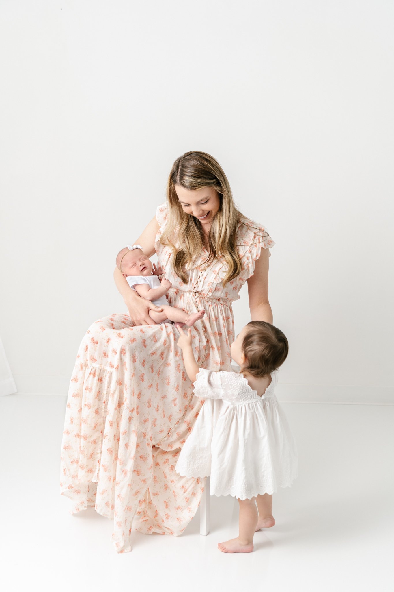  Nicole Hawkins Photography captures a mother with her newborn baby and toddler little girl. two little girls white dress mother poses newborn portraits #NicoleHawkinsPhotography #NicoleHawkinsNewborns #StudioNewborn #StudioFamily #EastCoastNewbornPh