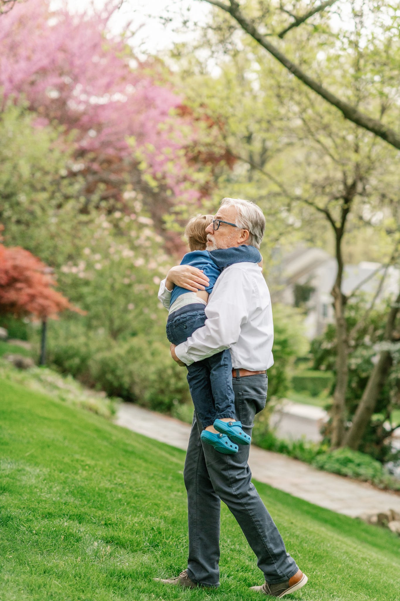  A grandpa hugs his grandson and carries him up the hill by Nicole Hawkins Photography. grandpa and grandson hugging grandfather hugs #NicoleHawkinsPhotography #NicoleHawkinsfamilies #AtHomePortraits #EastCoastFamilyPhotographer #NewJerseyInHomePhoto