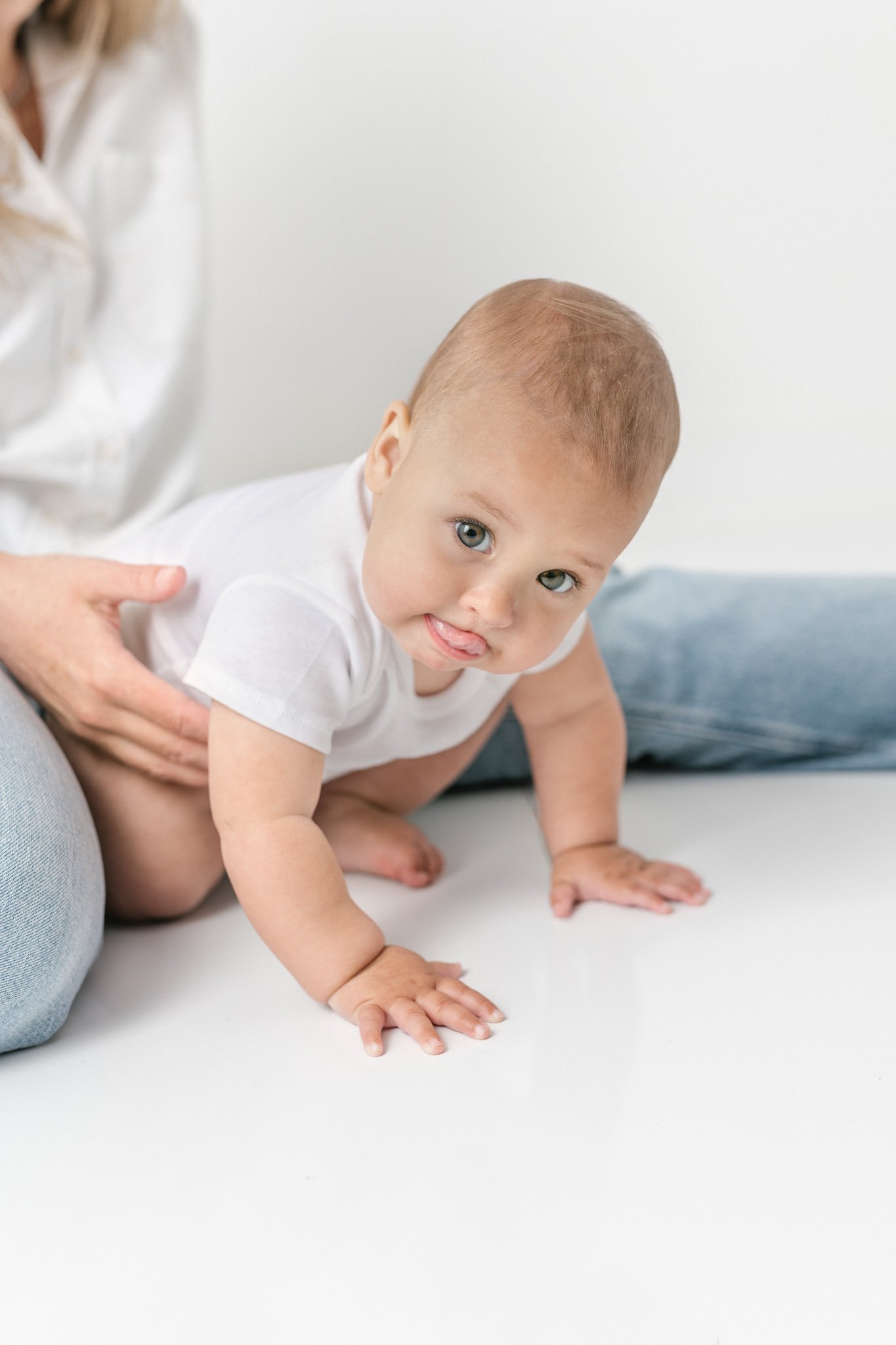  Baby portraits by Nicole Hawkins Photography capture a baby with her tongue out while she learns to crawl. baby with chunky hands learning to crawl #NicoleHawkinsPhotography #NicoleHawkinsNewborns #studionewborns #studioportraits #babystudioportrait