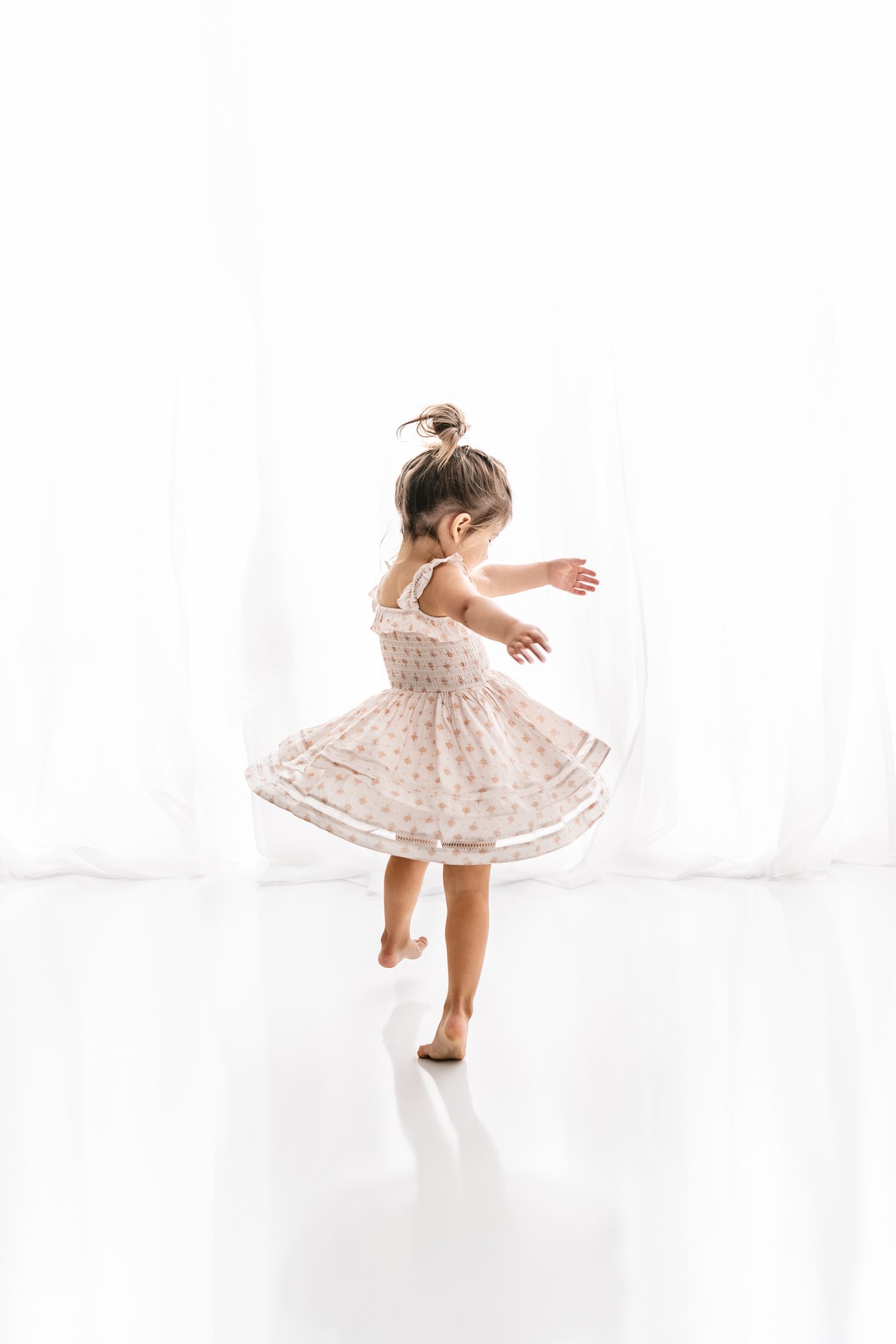  A timeless portrait of a little girl twirling around dancing in her dress captured by Nicole Hawkins Photography. little girl dancing top knot little girl dancing portrait in studio #NicoleHawkinsPhotography #NicoleHawkinsMaternity #MaternityStudioP
