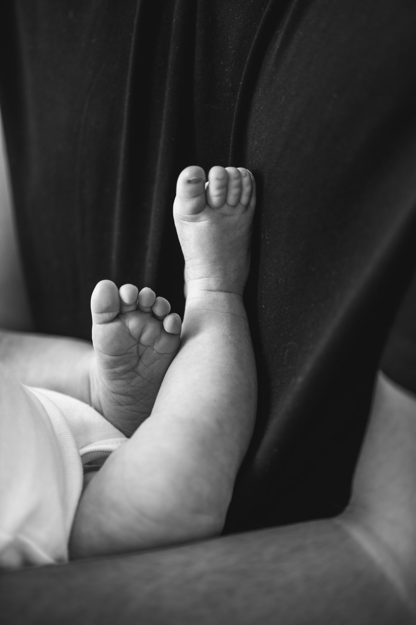  The cutest baby feet and toes close up in timeless black and white. Baby rests legs on father’s chest. Tender moment between baby and dad captured by Nicole Hawkins Photography in New Jersey. #newbornportraits #newbornstudioshoots #NewJerseyPhotogra
