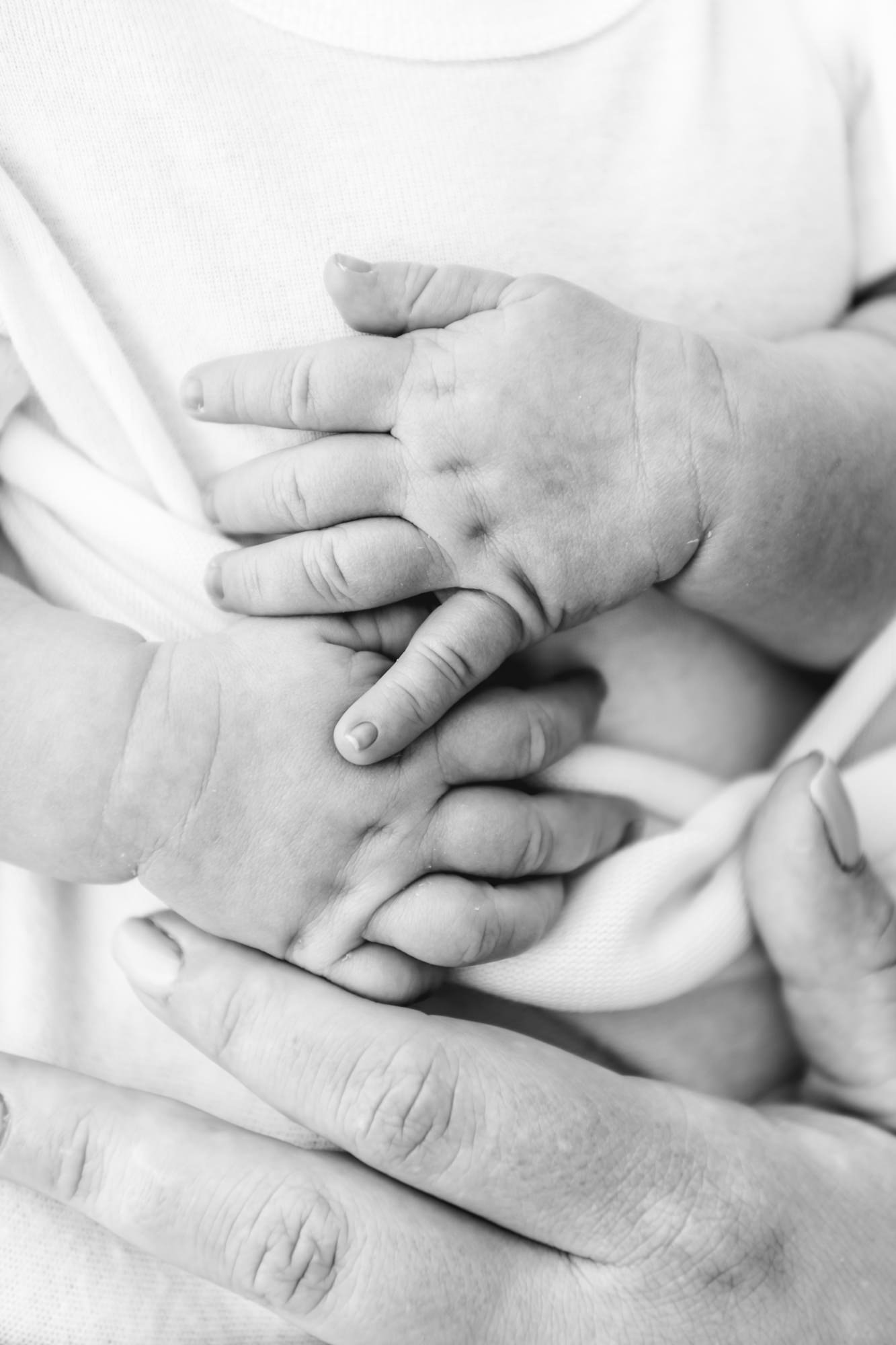  The most adorable baby hands in classic black and white photo. Mom places hand over baby’s stomach. Sweet baby dimples in hands in photo captured by Nicole Hawkins Photography. #newbornportraits #newbornstudioshoots #NewJerseyPhotographers #NJfamily