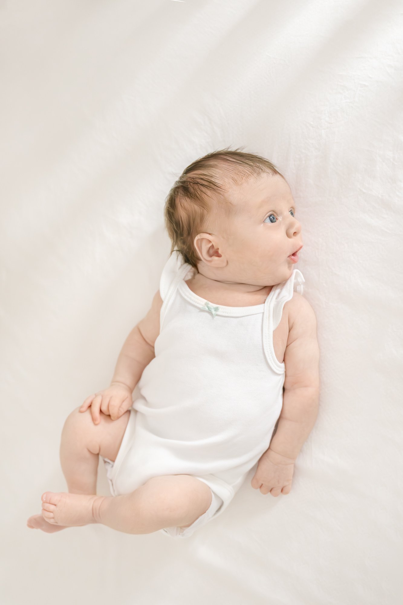  In the comfort of your home, Nicole Hawkins Photography, your North Central New Jersey Newborn Photographer, skillfully captures a precious, scrunched newborn face, ensuring timeless memories that will last a lifetime. #centralNewJerseyphotographer 