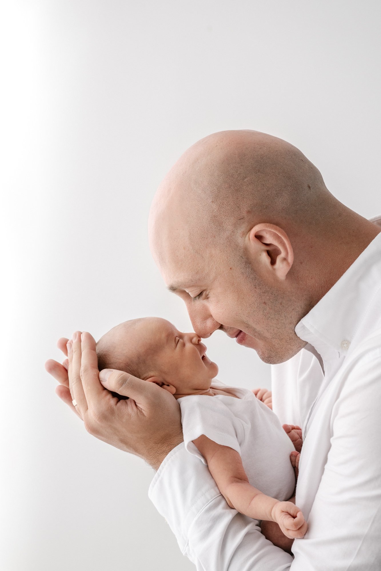  The sweetest dad holds his newborn close to his face so they are nose to nose. This classic pose was captured by Nicole Hawkins photography, a New Jersey based photographer.&nbsp; #instudionewbornsession #NicoleHawkinsphotography #newbornportraits #