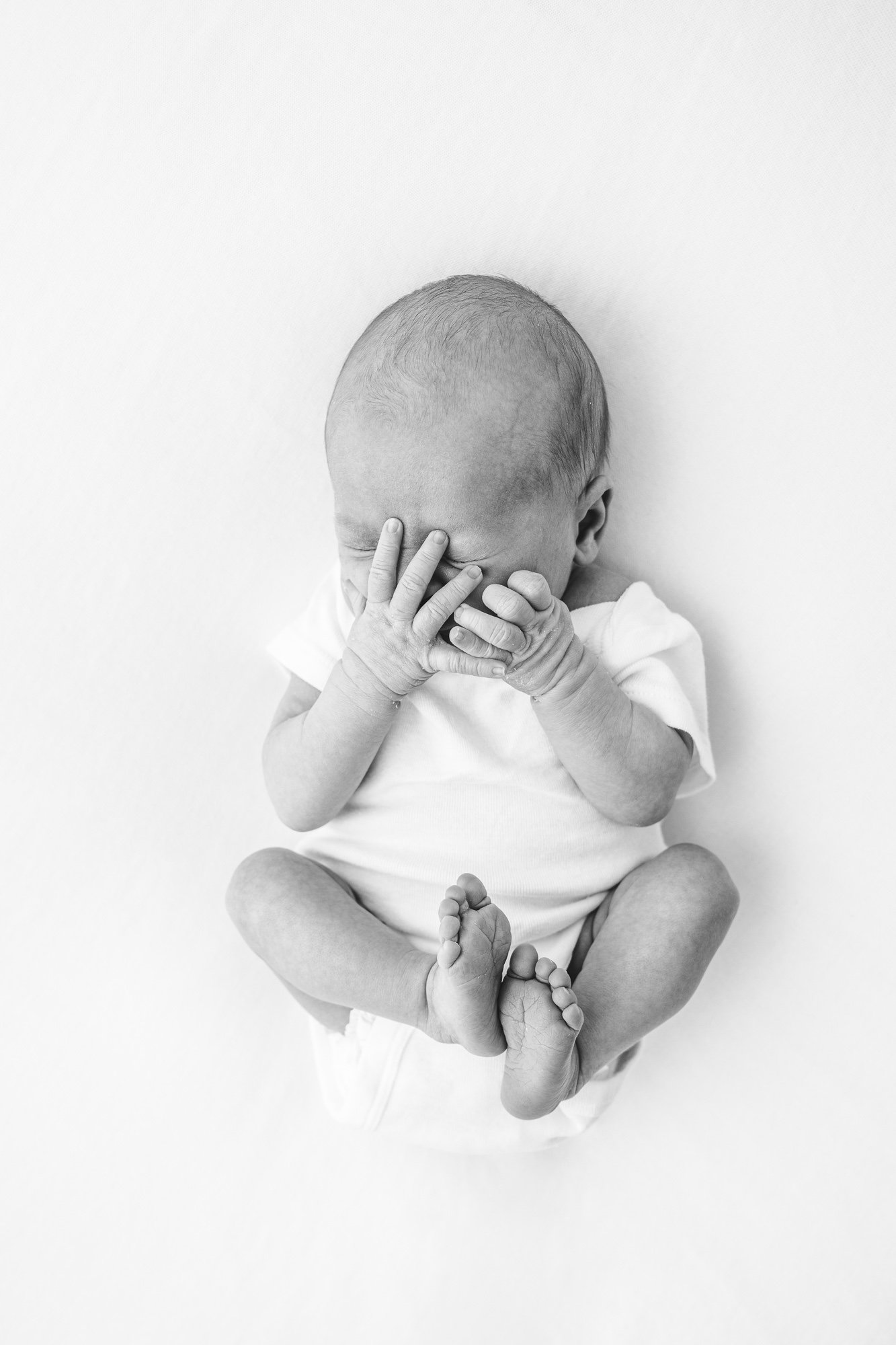  The cutest newborn covers her face with her hands and keeps her feet close to her body. Nicole Hawkins photography captured the cutest moment in New Jersey portrait studio. #instudionewbornsession #NicoleHawkinsphotography #newbornportraits #NewJers