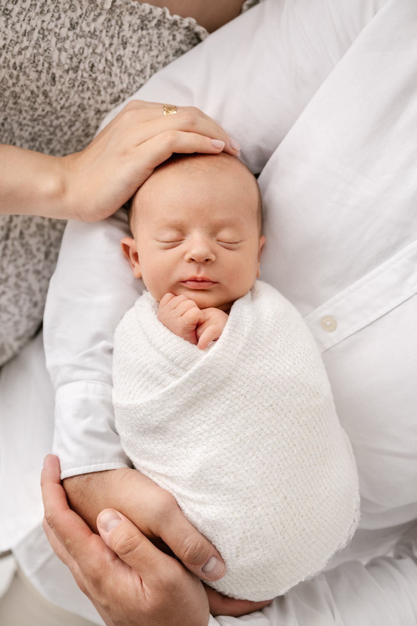  The sweetest newborn wrapped tightly in a swaddle sits on father’s lap during Nicole Hawkins photography session. Timeless newborn image. #instudionewbornsession #NicoleHawkinsphotography #newbornportraits #NewJerseynewbornphotographer #NewJerseypor