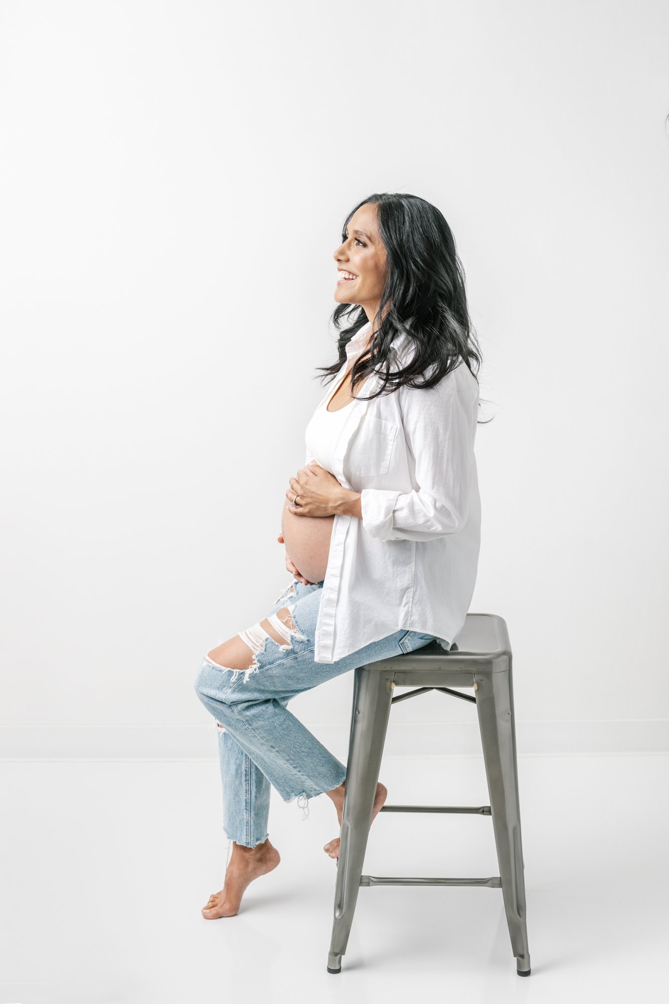  Pose inspiration for maternity photo sessions utilizing a bar stool for the pregnant mother to sit and rest while posing. #southorange #newjerseyphotographers #maternitysession #maternityposeinspo #studiophotography #formalmaternitystyle #casualmate