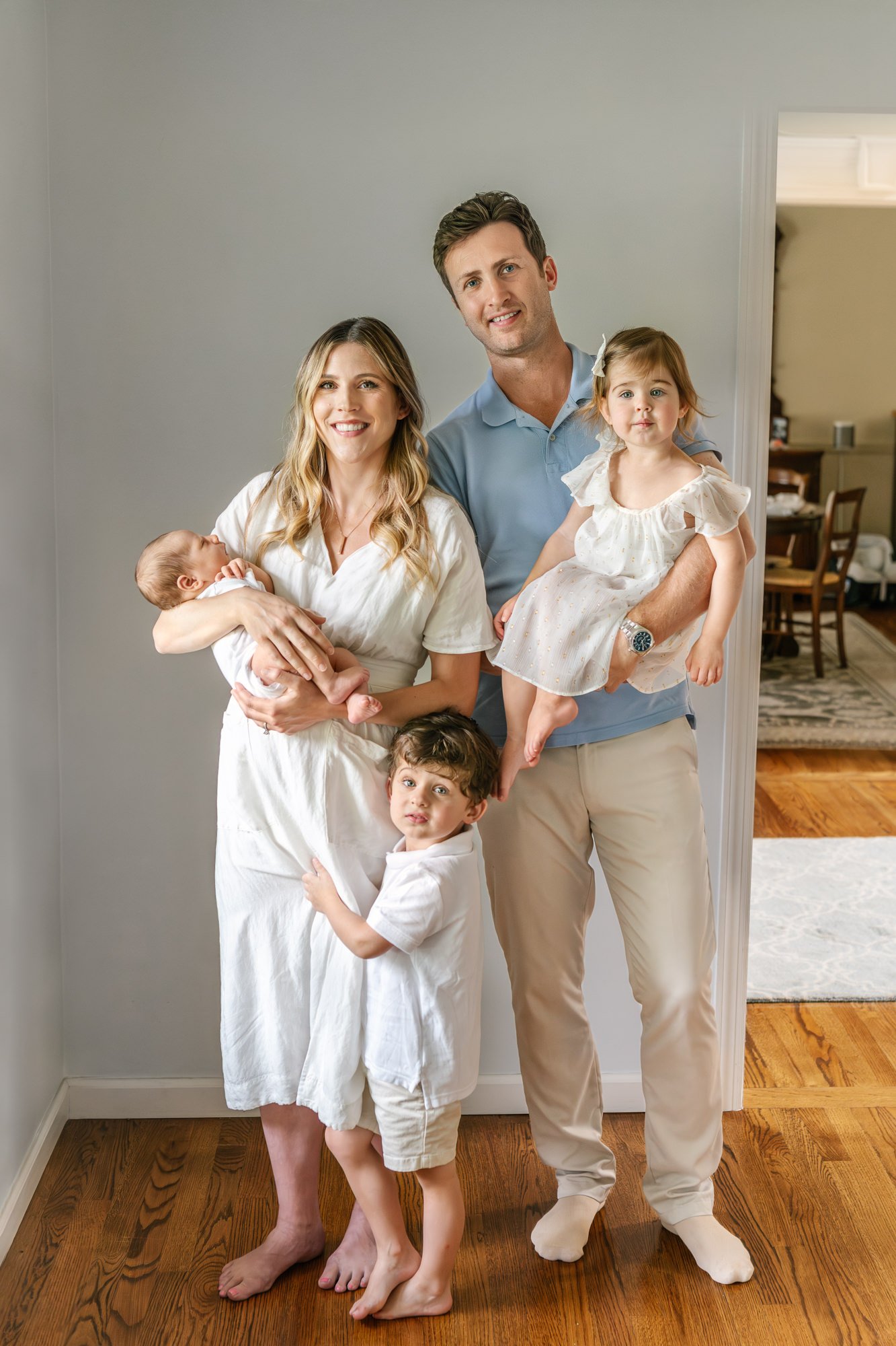  Family portraits featuring two happy parents with their three young children, including two toddlers and one newborn son. #candidposeinspo #newbornphotography #shorthillsphotographer #familyphotographersinnewjersey #inhomeportraits #newbornposeinspi