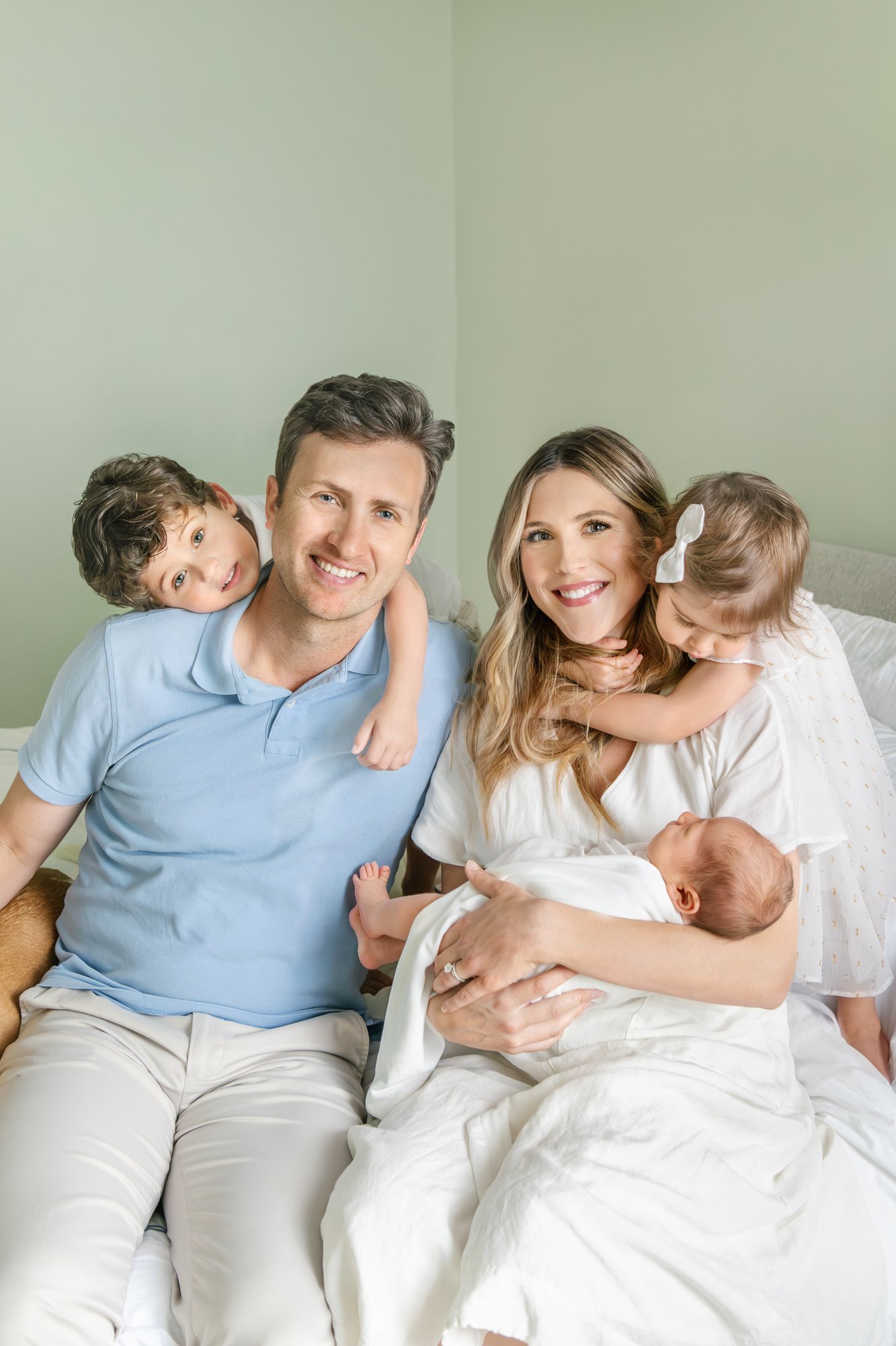  Nicole Hawkins captures a family portrait of two parents with their three children during their newborn session for their son. #candidposeinspo #newbornphotography #shorthillsphotographer #familyphotographersinnewjersey #inhomeportraits #newbornpose