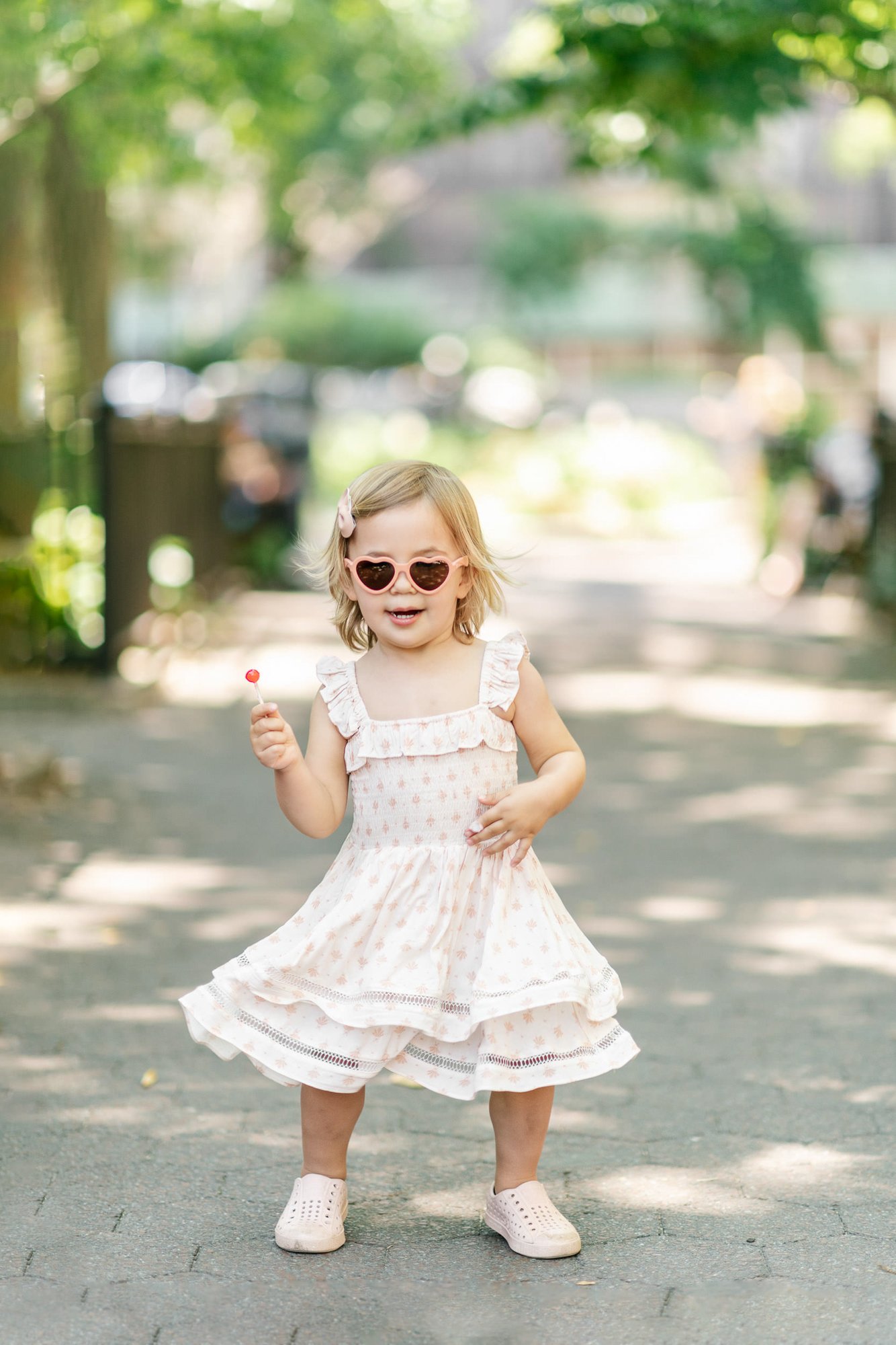   Outdoor family photoshoot with toddler girl walking down a pathway twirling in her dress. Toddler photo pose ideas family photo pose suggestions #EssexCountyFamilyPhotographer #MorrisCountyFamilyPhotographer #NorthernNewJerseyFamilyPhotographer #No