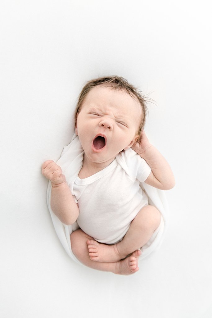   Photo of new baby stretching and yawning during newborn portrait session, taken by Nicole Hawkins Photography. Newborn photo inspiration #UnionCountyFamilyPhotographer #BergenCountyFamilyPhotographer #NorthernNewJerseyFamilyPhotographer #NorthernNe