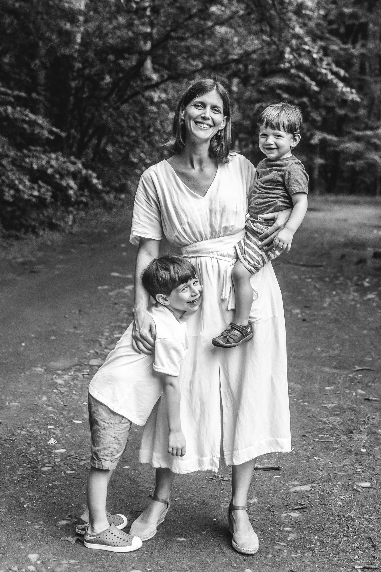   Black and white portrait of mom with two sons, standing outside in a field. Mother son pose ideas for family photos, mom and baby pose suggestions #EssexCountyFamilyPhotographer #MorrisCountyFamilyPhotographer #ManhattanFamilyPhotographer #Northern
