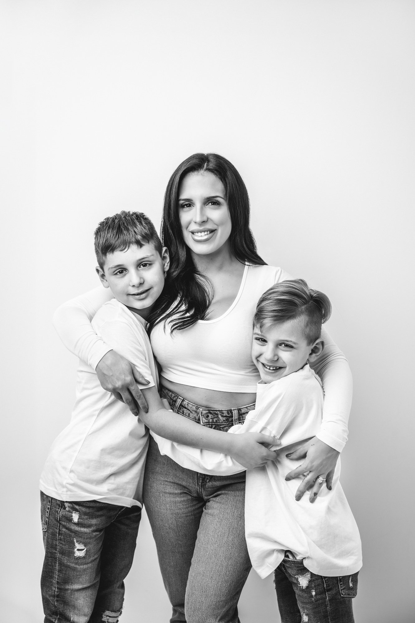   Black and white photo of mom hugging two sons during family photos with Nicole Hawkins Photography. Mother son photo inspiration #UnionCountyFamilyPhotographer #PassaicCountyFamilyPhotographer #ManhattanFamilyPhotographer #NorthernNewJerseyPhotogra