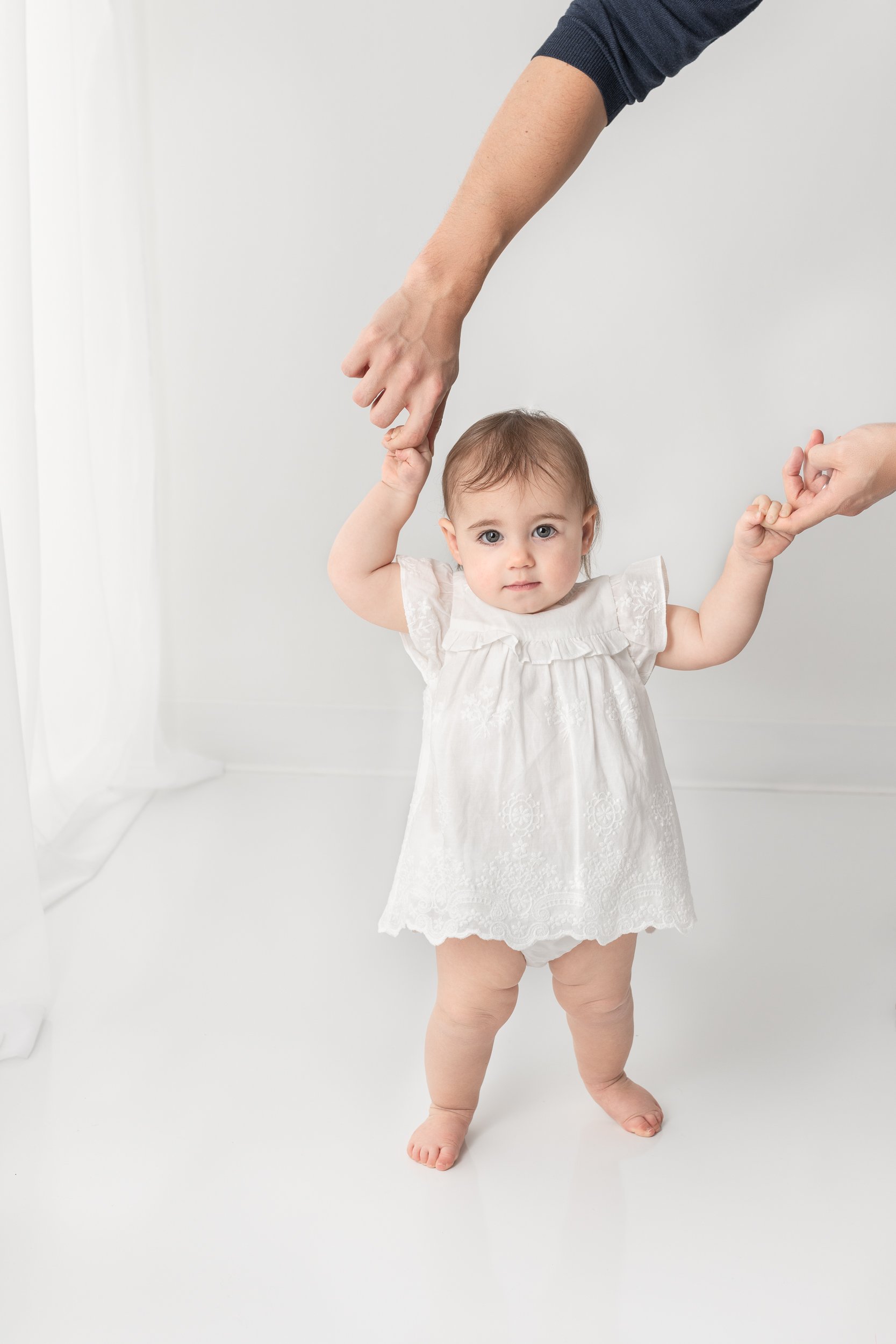   First birthday portrait of baby girl walking holding dads hands. First birthday photo inspiration baby photos pose ideas #EssexCountyFamilyPhotographer #MorrisCountyFamilyPhotographer #NorthernNewJerseyFamilyPhotographer #ManhattanPhotographer #Pas