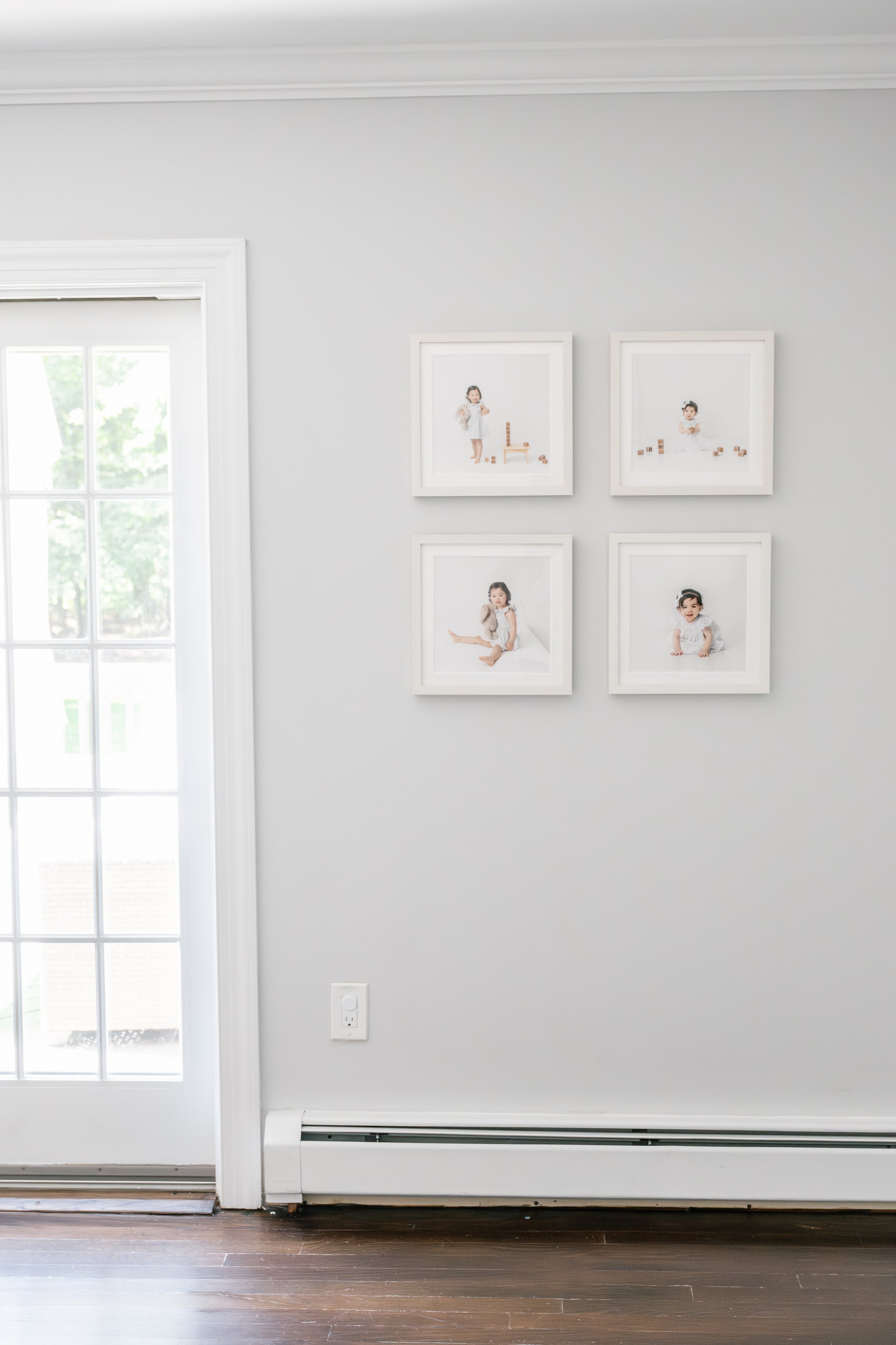   Square gallery wall with four framed photos with identical frames, filled with photos of a toddler and a baby playing with toys. #EssexCountyFamilyPhotographer #MorrisCountyFamilyPhotographer #NorthernNewJerseyFamilyPhotographer #NorthernNewJerseyP