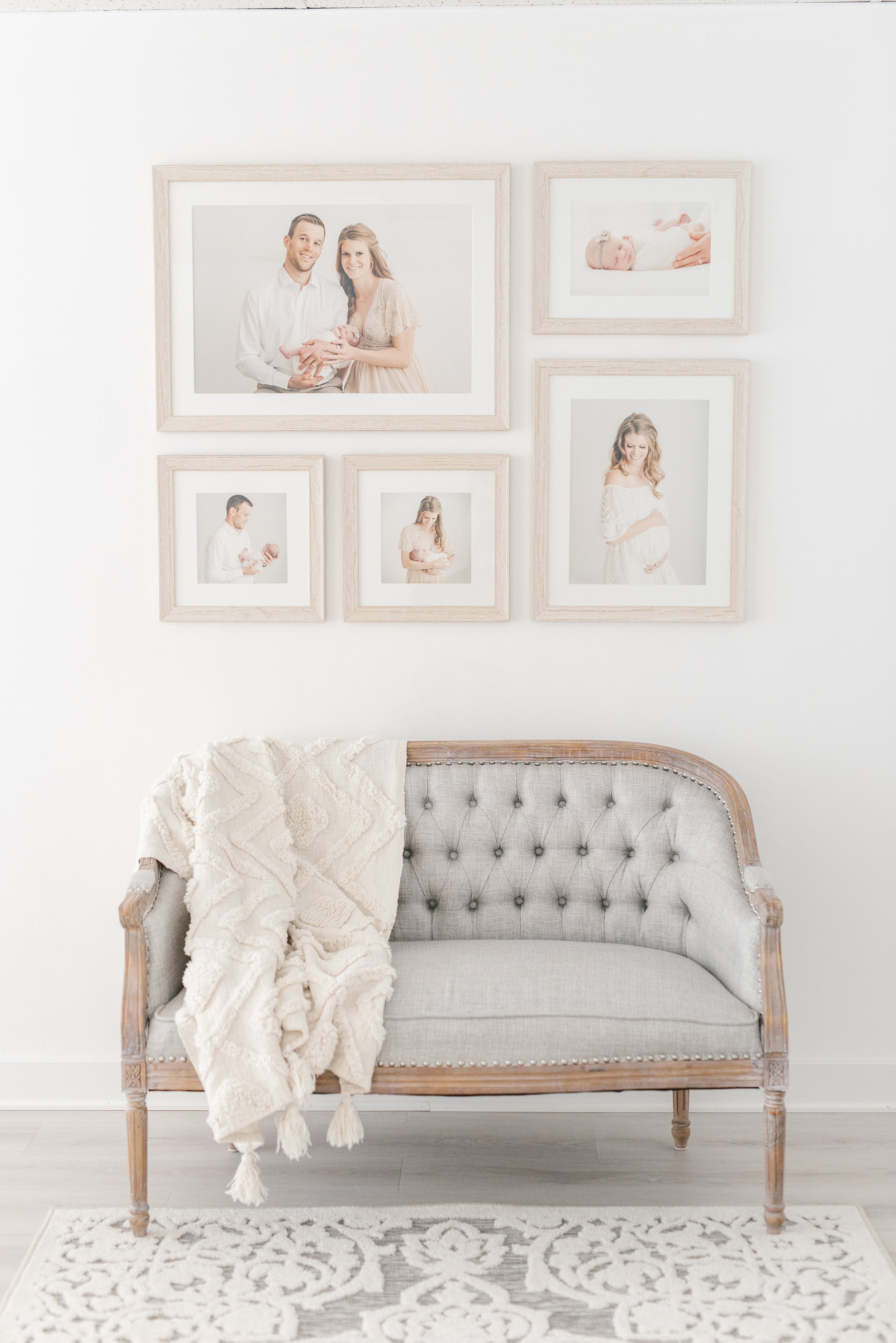   Gallery wall with five framed prints of maternity photos and newborn portraits, hung above a vintage settee. Gallery wall inspiration #EssexCountyFamilyPhotographer #PassaicCountyFamilyPhotographer #NorthernNewJerseyFamilyPhotographer #NorthernNewJ