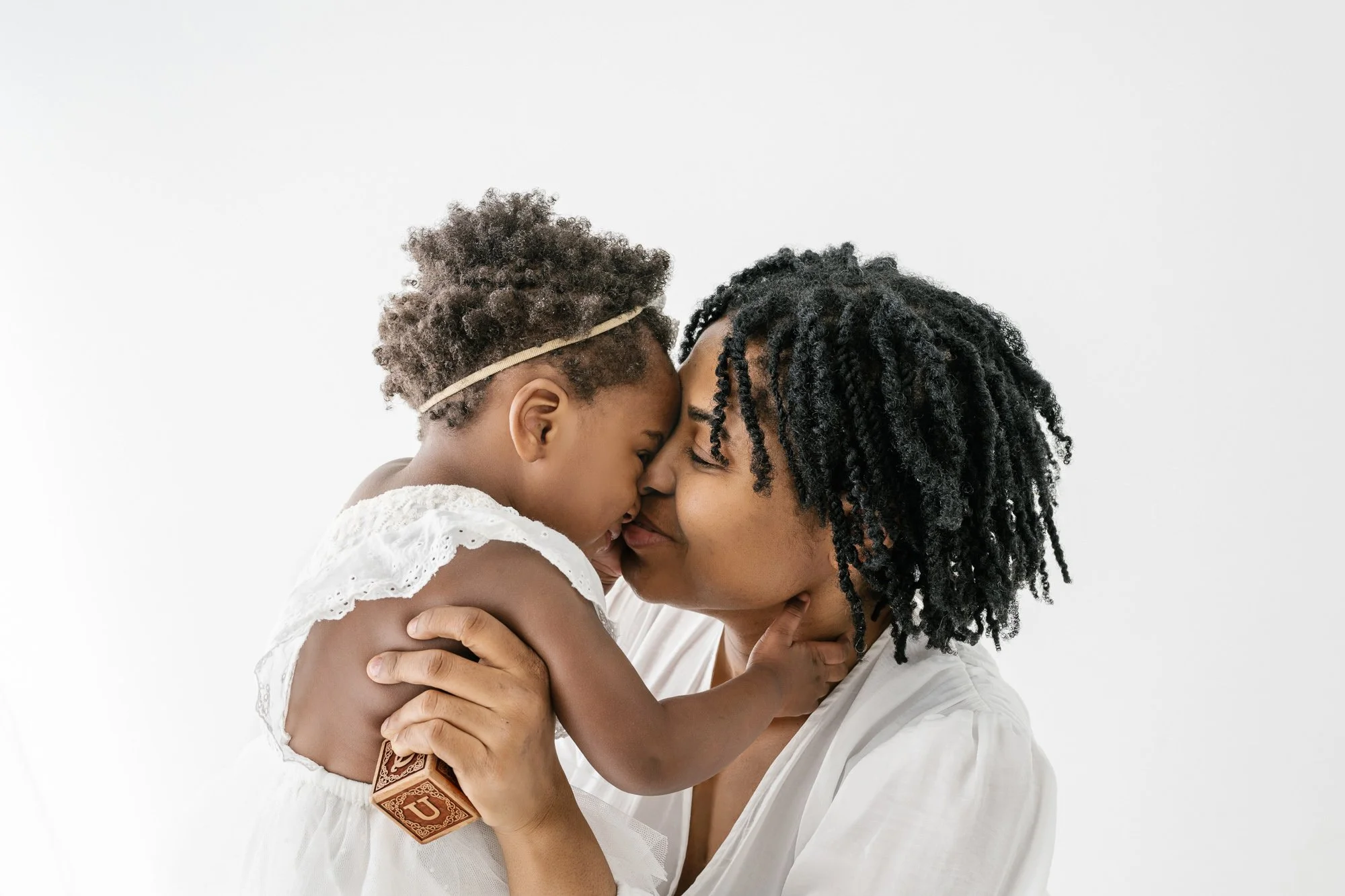 Mother and one year old baby girl snuggling in New Jersey photo studio
