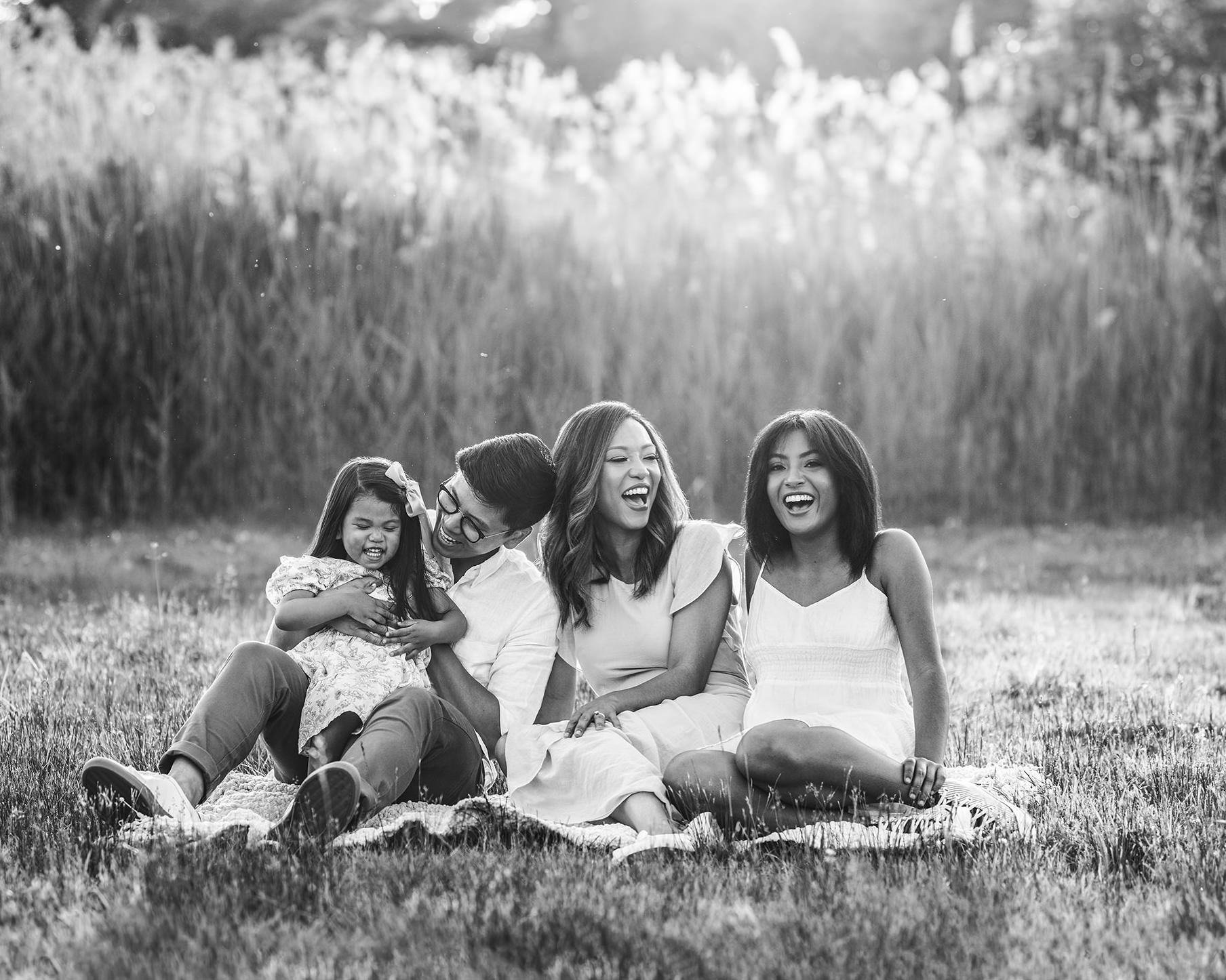 laughing family in natural portrait sitting outside in summit new jersey park