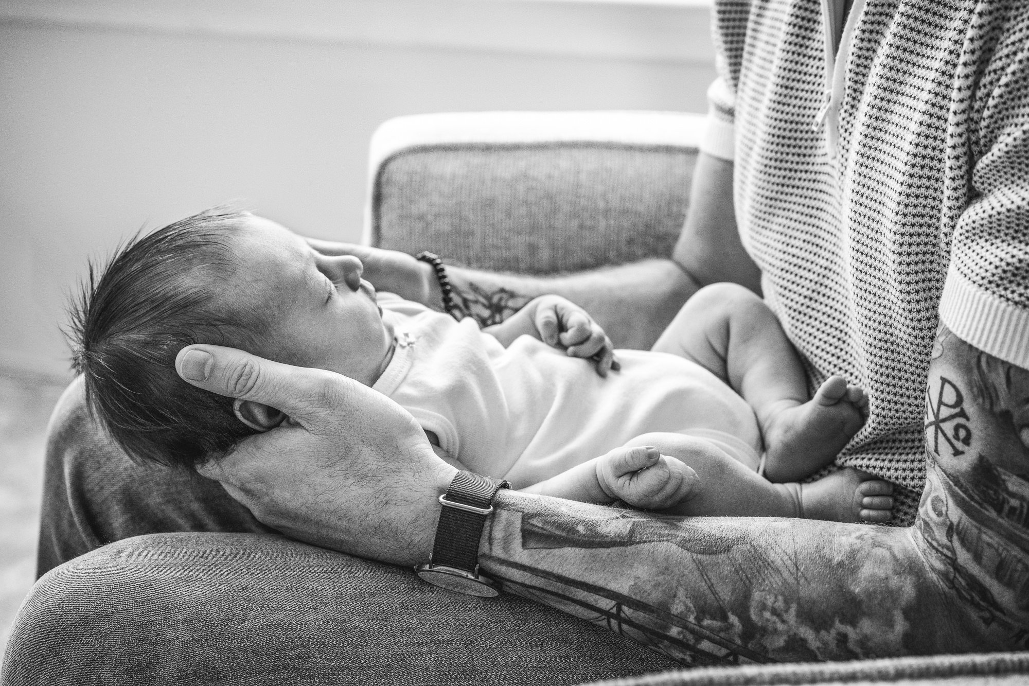 Dad holds his newborn daughter in a rocker in their darling, neutral nursery. In-home newborn photography session captured by Nicole Hawkins photography.  #centralNewJerseyphotographer #inhomeportraits #newbornphotoshoot #NewJerseyPhotographers