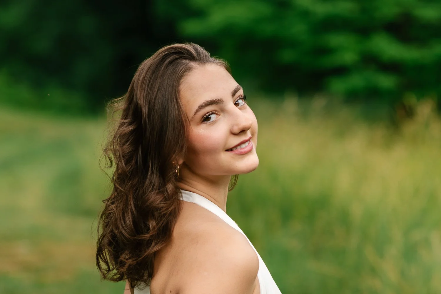 Close up outdoor senior portrait with tall grasses in the background at Cross Estate Gardens
