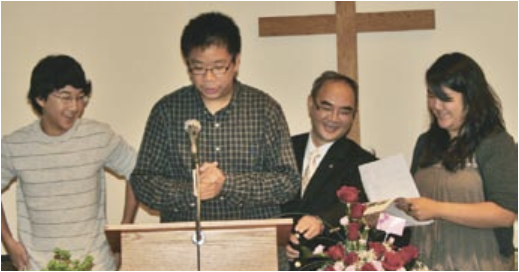   Pastor Paul Mo, second from right, joins Markham Chinese Mennonite Church youths Clement Mo, left, Daniel Li and Fiona Mo as they share memories and pictures of growing up in the church during 20th anniversary celebrations on Sept. 12.     Photo by Raymond Chan  