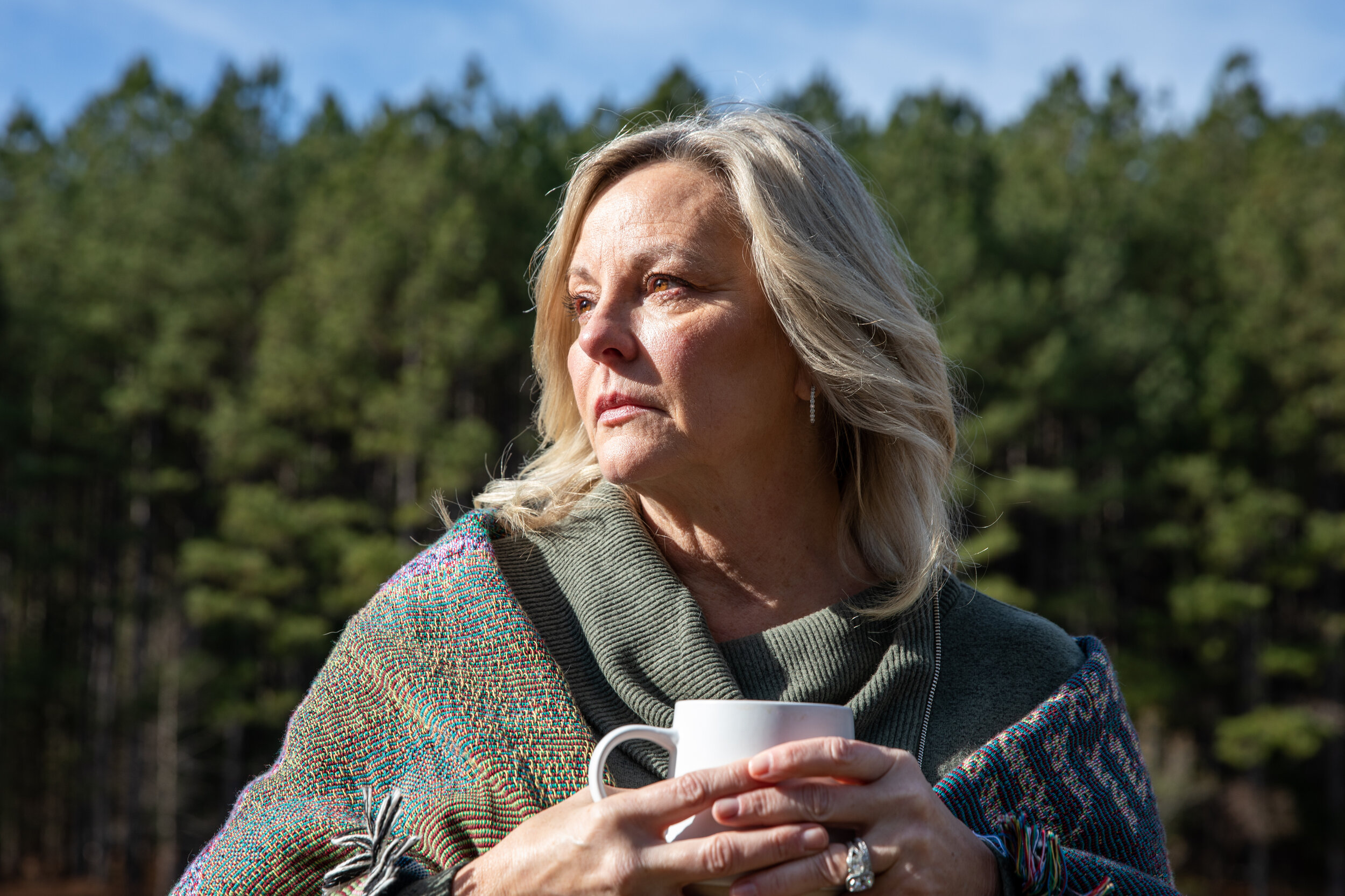  Cindy Bezzek stands near the pond on her property inSanford, North Carolina, on Dec. 19, 2020. Bezzek and her husband, Mark, lost their mothers to COVID-19; their daughter died of an overdose after not being able to receive care because rehabilitati