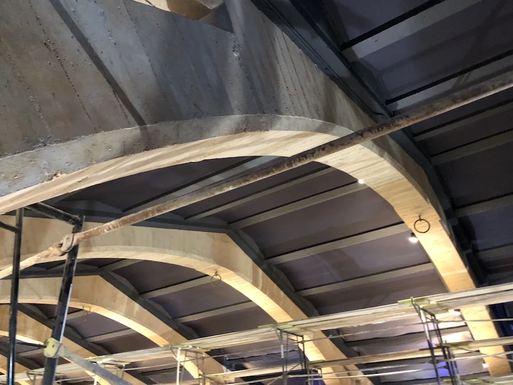 Original concrete texture in the arches and acoustically treated ceiling are featured.