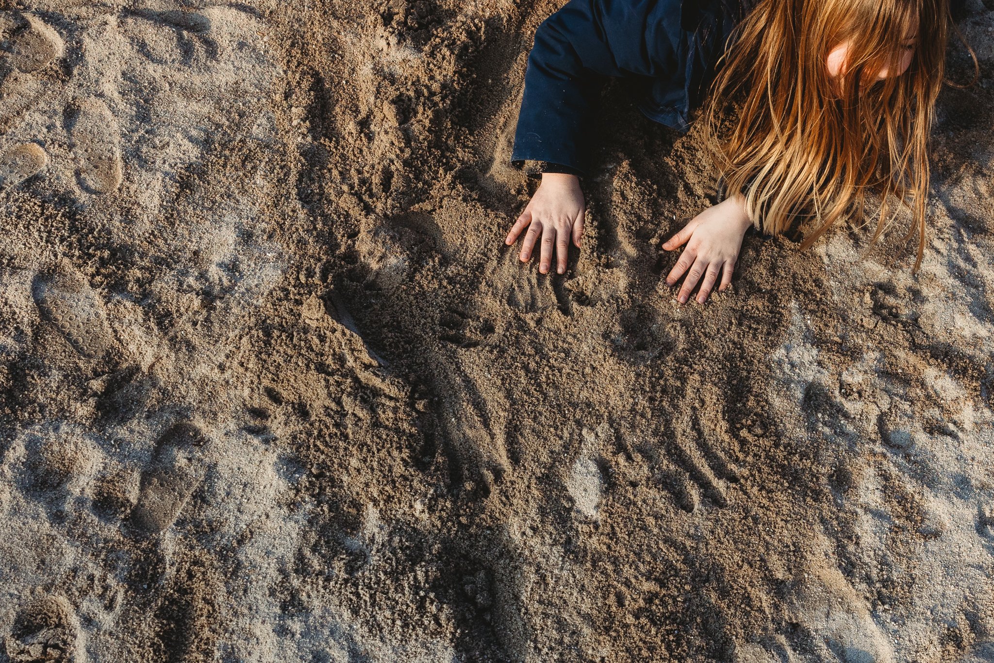 Girl's hands in sandpit