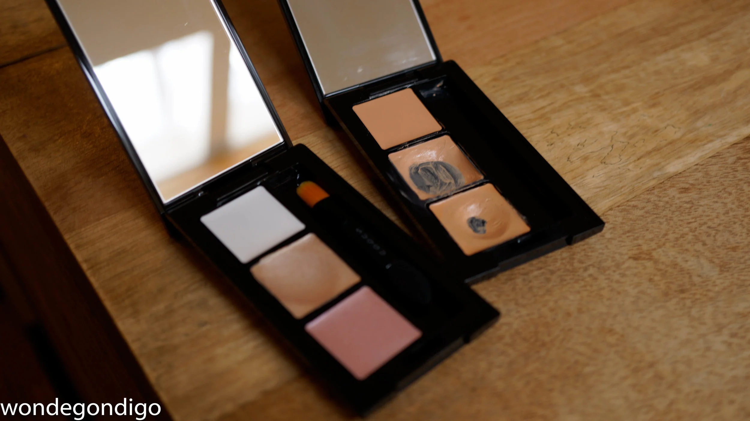 Two cases I've filled. Left side has the three highlighting shades, and the right side has the concealing products. I have duplicates of the corrector (top pan which is brand new, and the middle pan with the giant... pan)