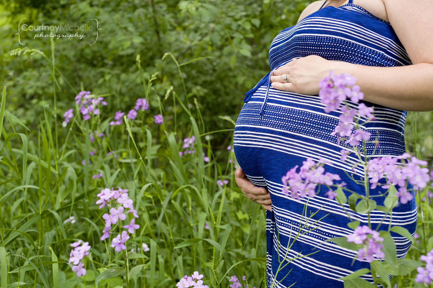 pregnant-belly-in-grassy-field-with-wildflowers-wisconsin-maternity-photography-by-courtney-laper.jpg