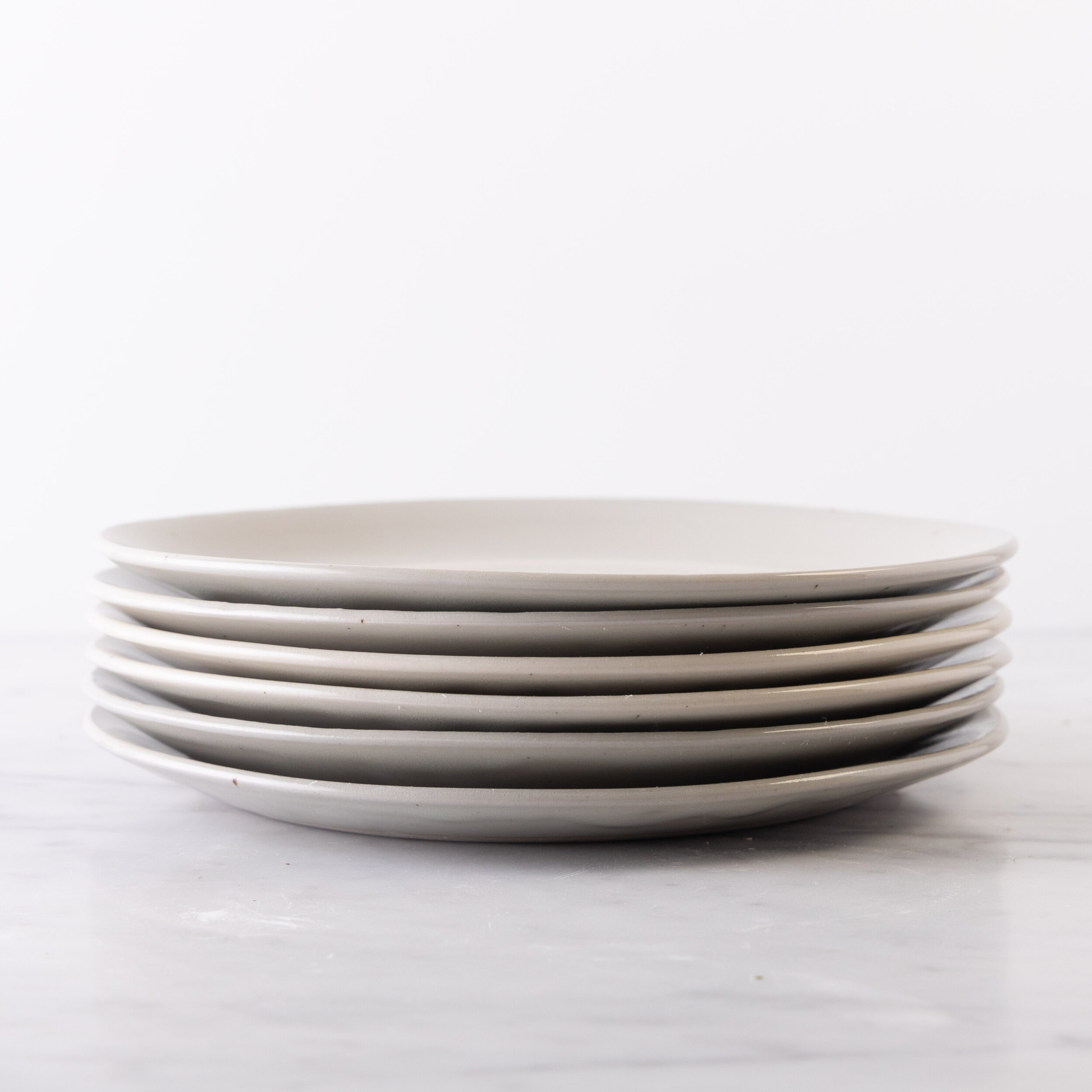 The two middle plates (shown in Mist Glaze) are slightly lighter than the others.  These color differences are acceptable. The shift in the form of the plates pictures is also acceptable.