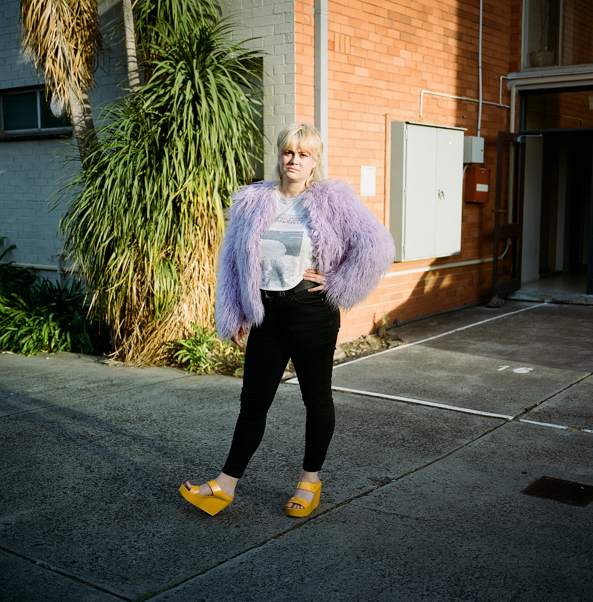 Nellie posing in front of the apartment lot where she lives, Melbourne, 2019