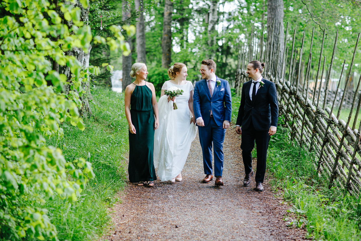  Brudepar går sammen med sine forlovere på en sti i skogen 