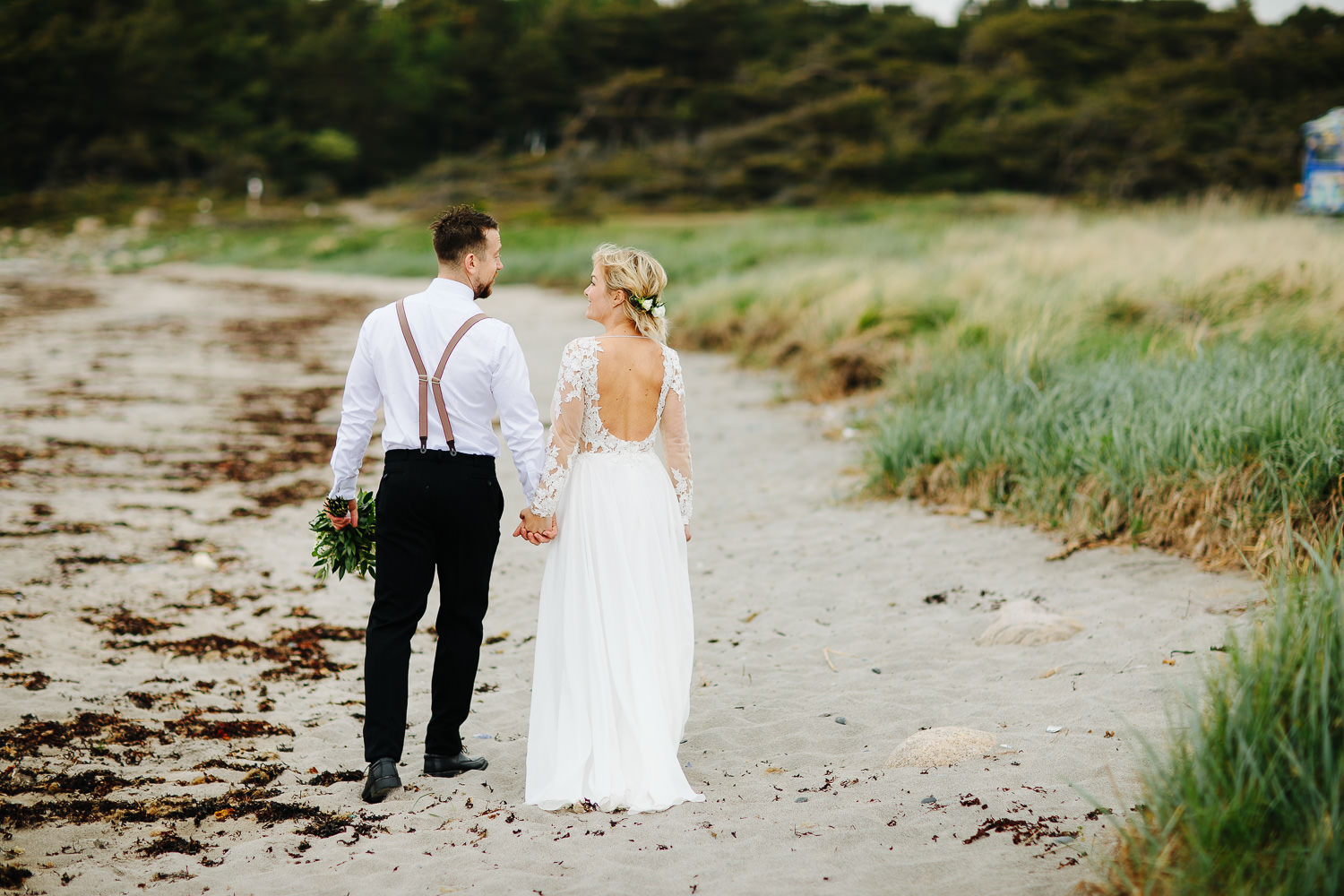  Brudepar går bortover stranden på Hvaler.&nbsp; 