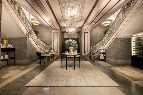 The Alter Spa interior with twin staircases, a chandelier and a round center table, hospitality interior photography by Jack Robert