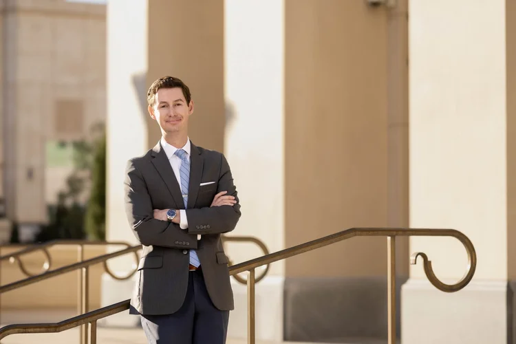 Attorney with arms crossed on courthouse steps, branding portrait