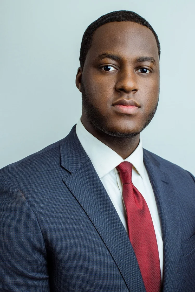 Professional attorney headshot in a navy suit and red tie