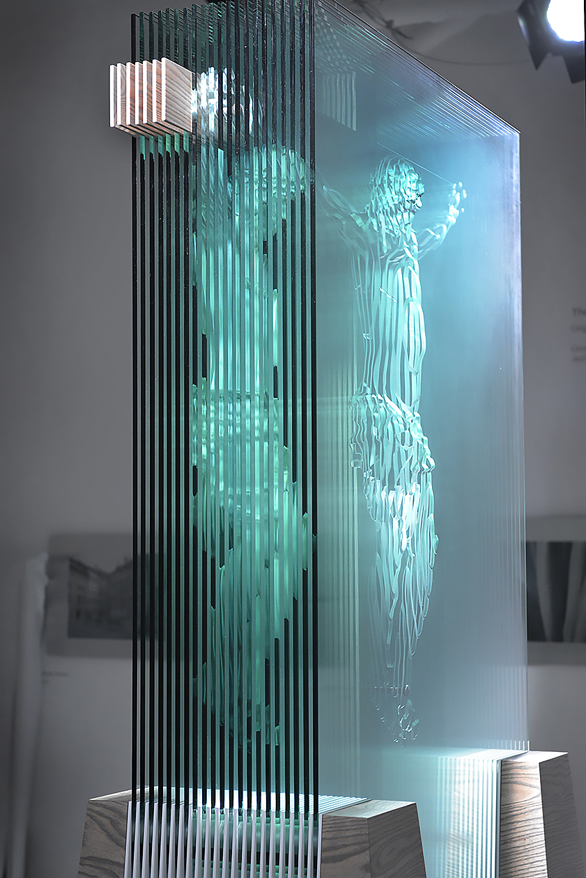 The Hidden Face of God glass sculpture, 10’ tall, side view showing figure of redirected light on the left.