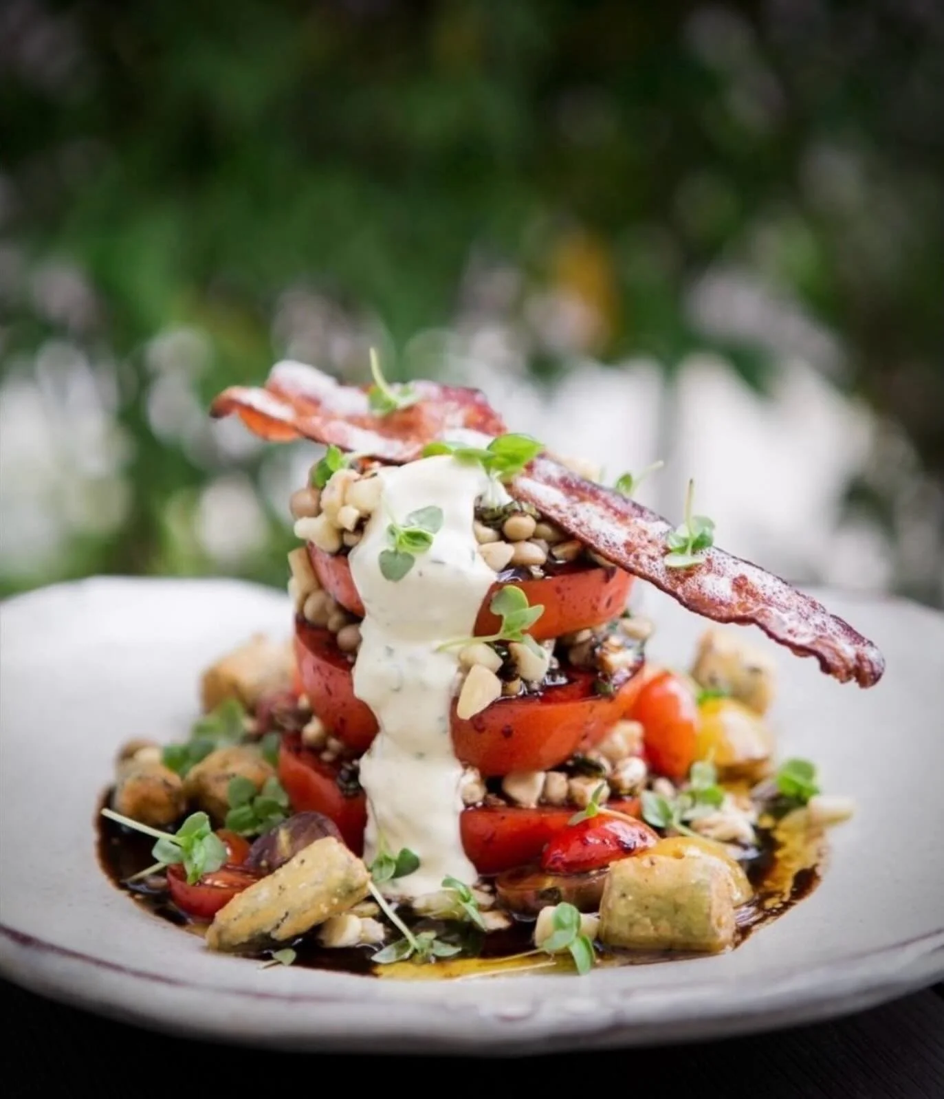 The wait is over 🍅
Our Tomato Salad will officially make its way onto the menu at Hot and Hot Fish Club tomorrow. 
Layered perfectly ripe tomatoes, crispy @nueskes bacon, sweet corn, field peas, chive aioli , and a rich balsamic vinaigrette finish &