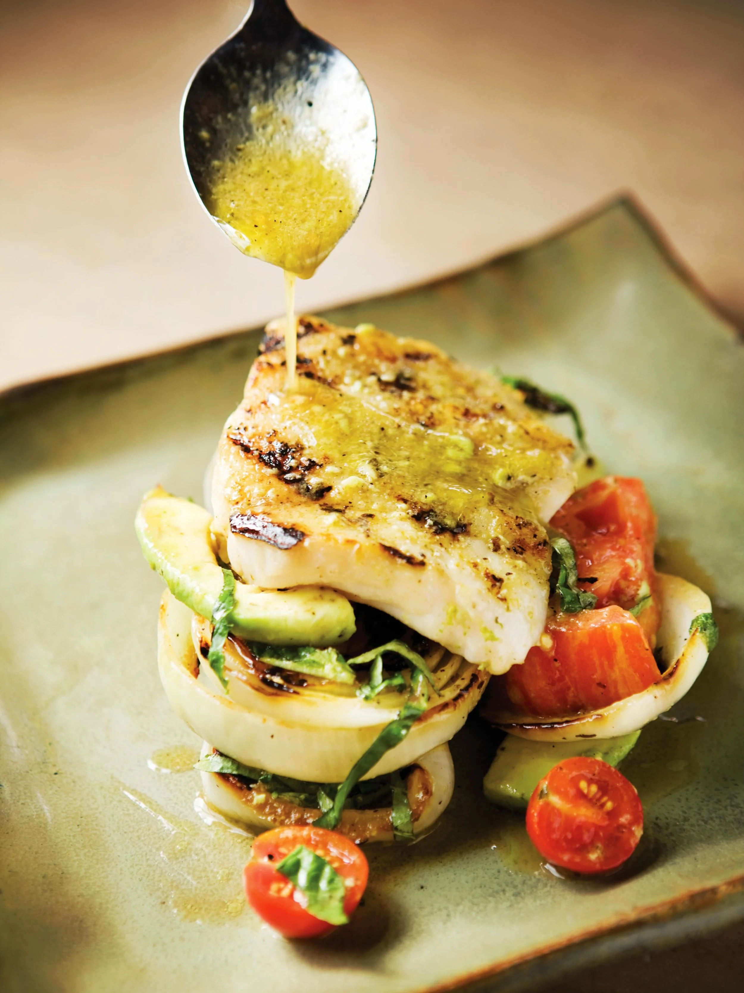 From the dock to the plate.
Our Oven Roasted Yellowedge Grouper is built around pristine Gulf fish, roasted and finished with a bright basil-lime vinaigrette. Served over charred Vidalia onions, ripe tomatoes, and creamy avocado &mdash; a dish that c