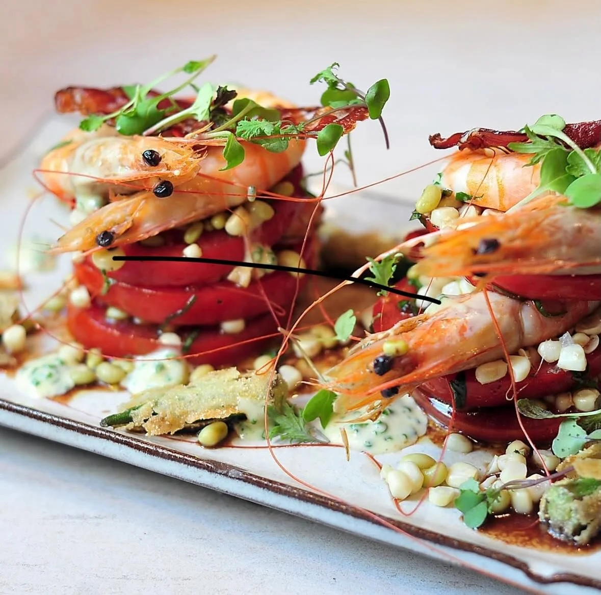 Peak season on a plate 🍅🦐
Our entree Tomato Salad featuring Bayou La Batre head-on shrimp, layered with ripe summer tomatoes, sweet corn, crispy okra, balsamic vinaigrette, field peas, and chive aioli.  Bright flavors, Gulf seafood, and Southern su