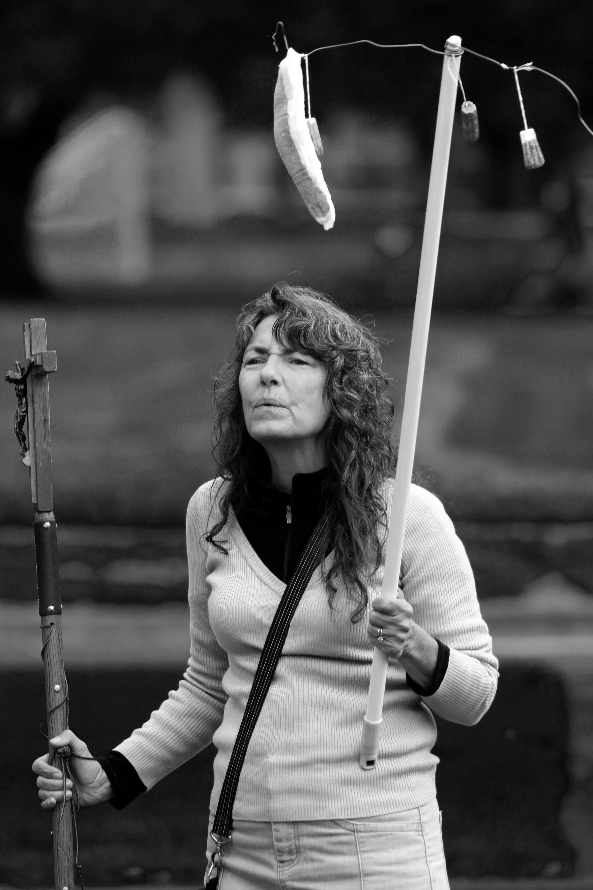 Cindy preaching with bloody tampons and a staff depicting Christ's crucifixion
