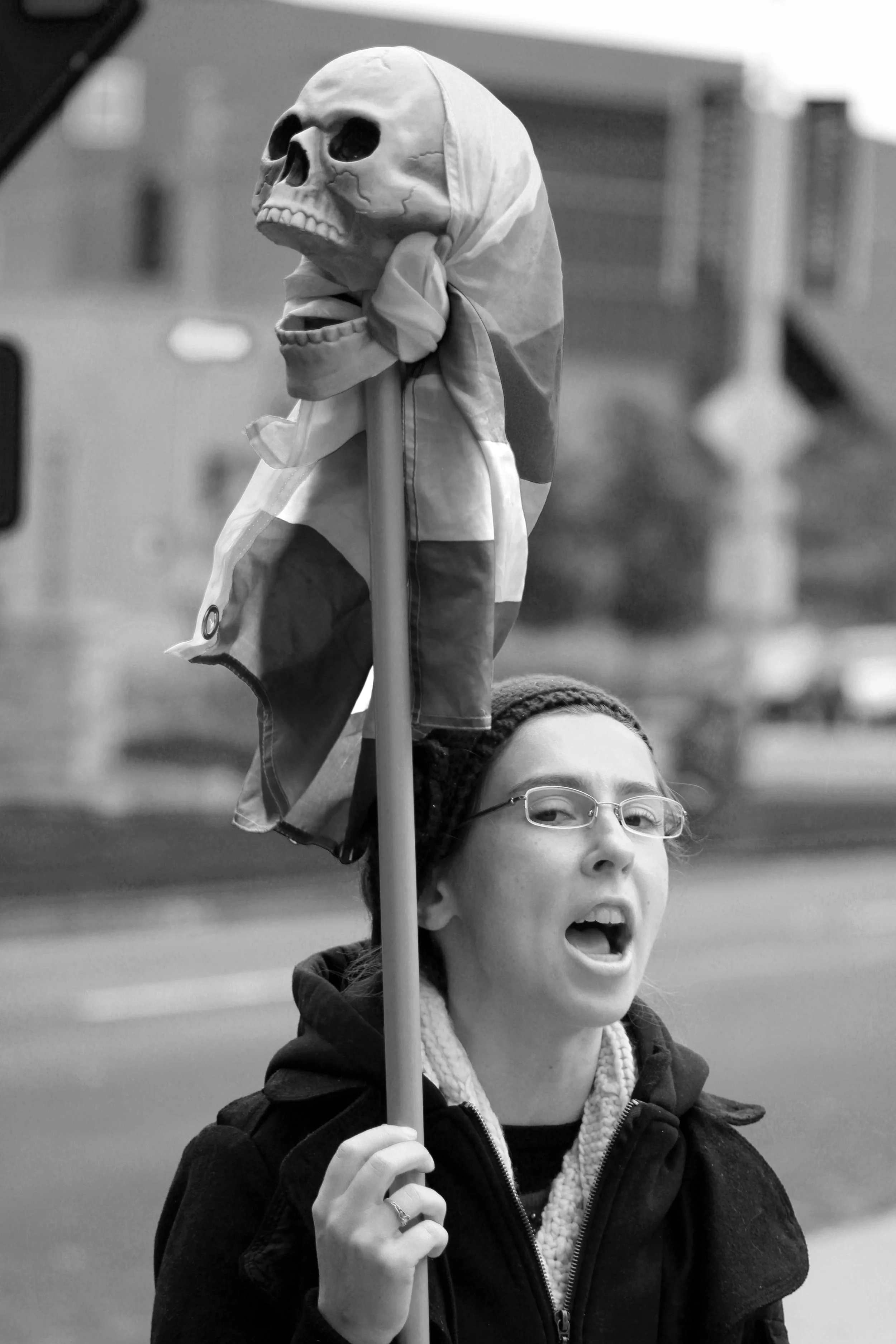 Kiersten preaching with a rainbow flag on a skull
