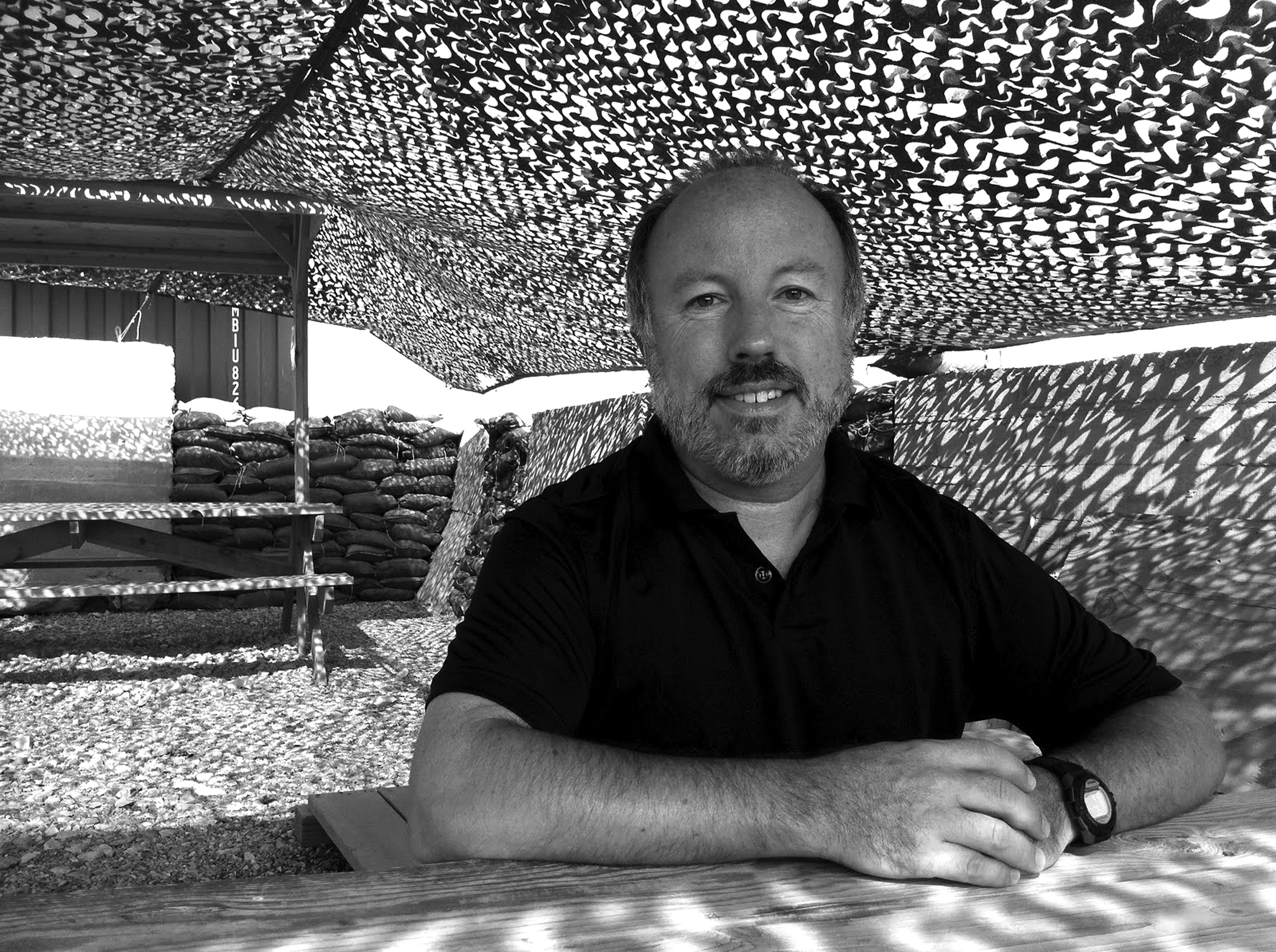 Davis relaxes at a table near his tent, protected by concrete walls and sandbags.