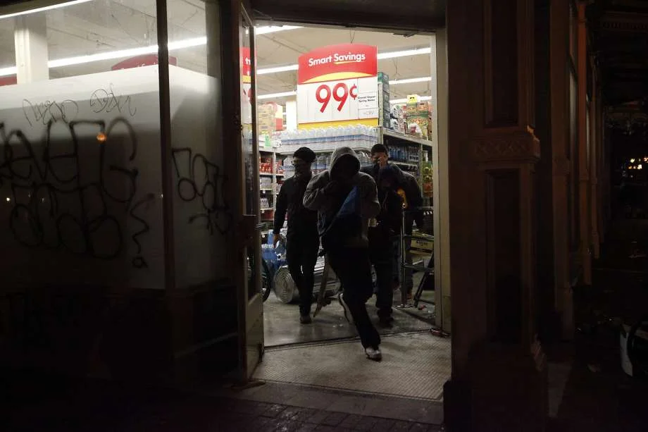 Photo: Leah Millis, The Chronicle - Vandals loot the grocery store Smart and Final after vandalizing the front and breaking the windows during a protest
