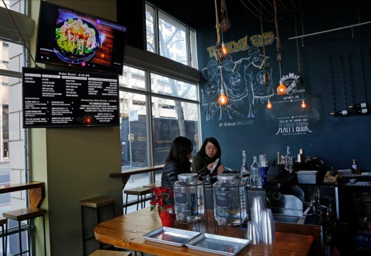 Customers decide to sit at the bar with their food during a soft opening after a re-structuring of AlaMar restaurant on Friday, Jan. 6, 2017 in Oakland, Calif. Nelson German, owner of AlaMar restaurant, decided to change his restaurant from a table-service model to a new fast-casual model in an effort to address the financial pressures he and other restaurant owners are up against. (Laura A. Oda/Bay Area News Group)