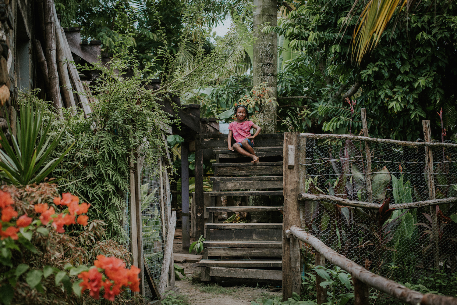 Josephine poses for a photo on her grandmother's front porch steps in Gales Point, Belize.
