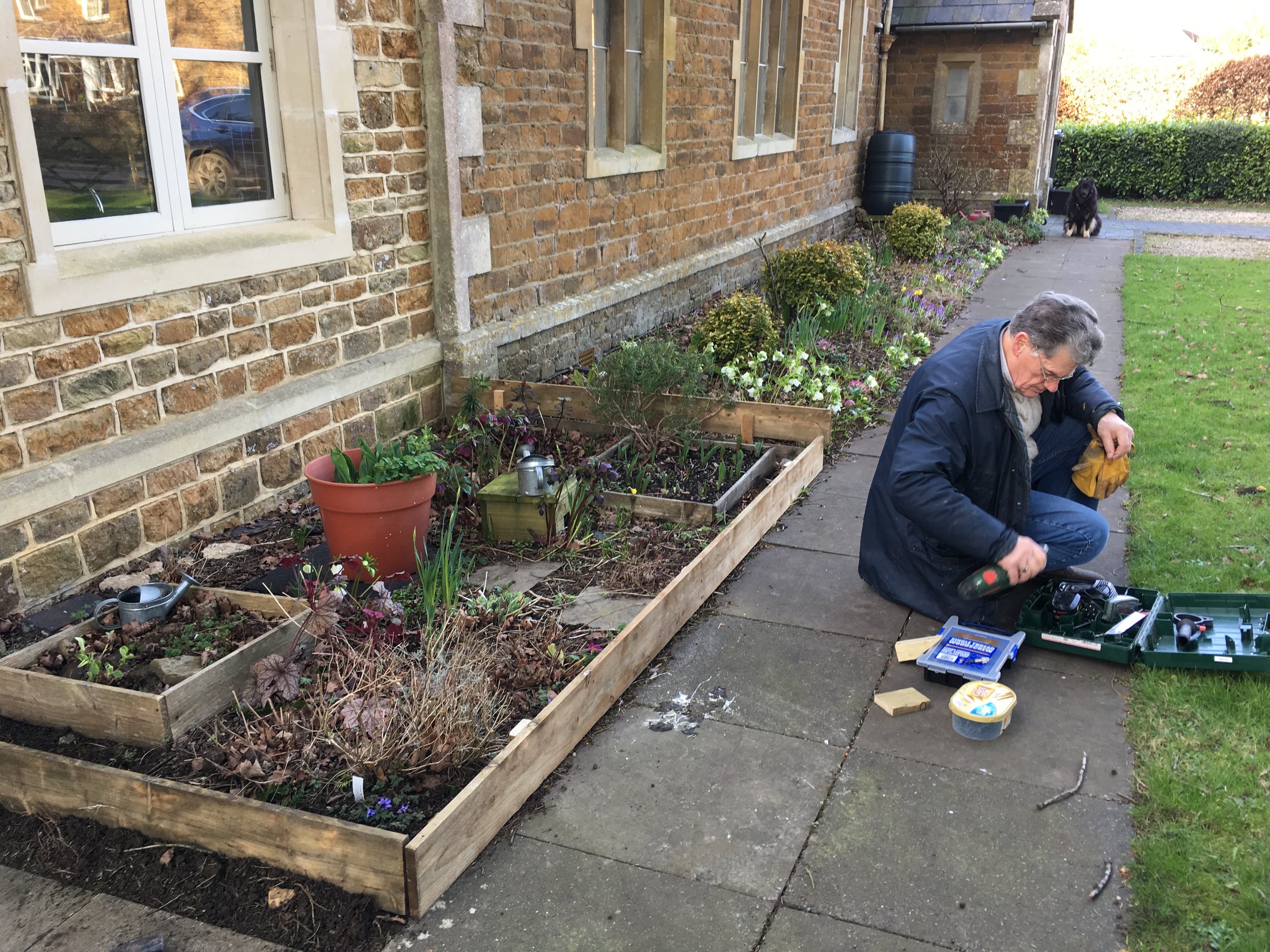 Eric, one of our volunteers, prepares to insert new edging to the Rainbows' bed at the Baptist Hall